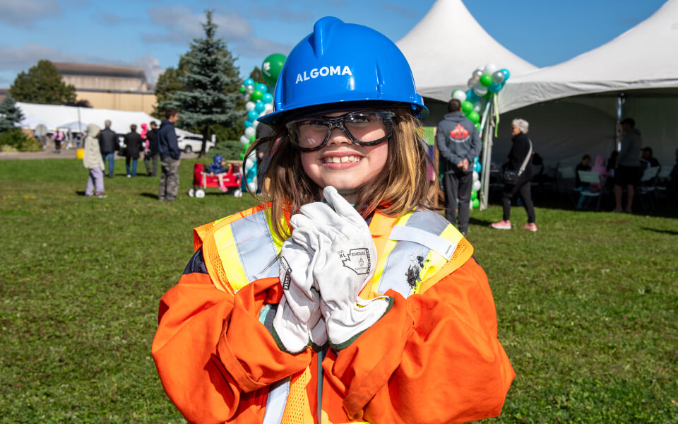 Young girl wearing an Algoma Steel hard hat